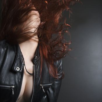 Pretty redhead young woman flipping head back with long hair flying out.