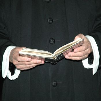A priest is reading from the bible.