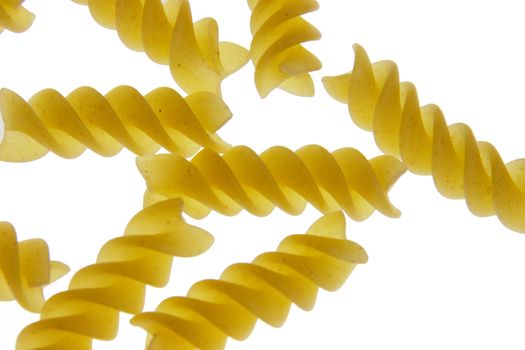 A bunch of pieces of fusilli pasta on a white background.
