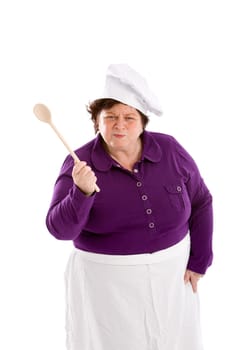 Mature female chef waving her wooden spoon and looking angry
