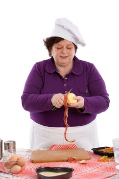 Female chef busy peeling an apple at the kitchen table