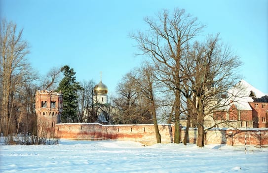 Red brick fortress wall and a church in winter