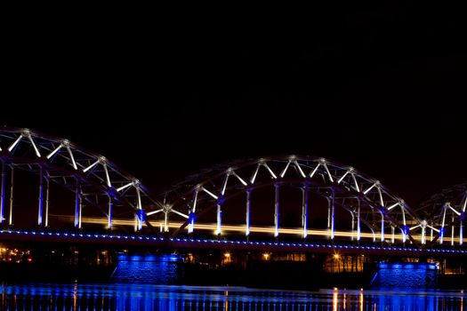 Illuminated Riga Railway bridge over river Daugava at night