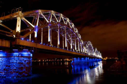 Illuminated Riga Railway bridge over river Daugava at night