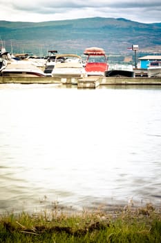 small lake bay with boats and mountains
