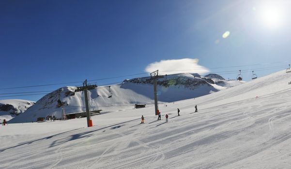Sun shining over a ski slope in the french alps. 