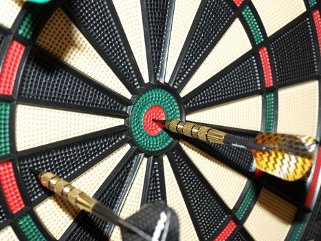 darts thrown at the board with one bullseye