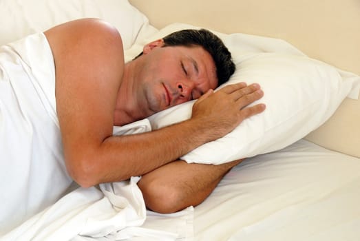 mature man sleeping on white pillow in bed