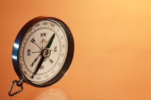 Closeup of compass standing on red background with copy space