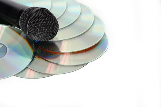 Black modern microphone lying on CD stack. Isolated with clipping path