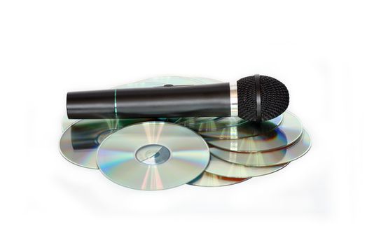 Black modern microphone lying on CD stack on white background