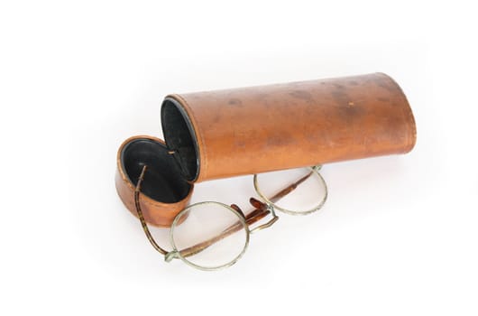 Old spectacles and vintage ginger leather case on white background