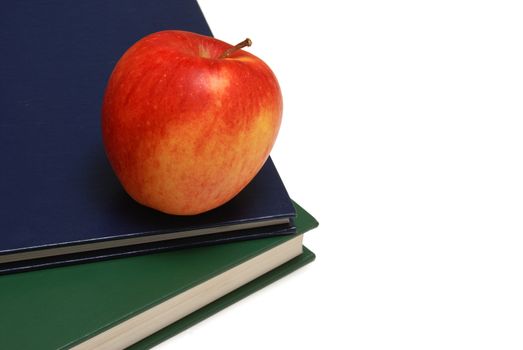 An apple resting on a couple of textbooks.