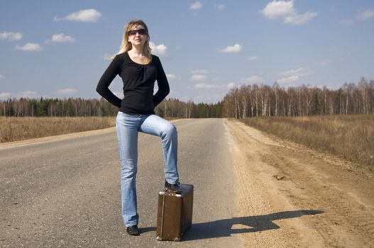 pretty girl waiting on the road with her baggage