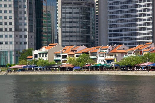 Old shop houses contrast with modern skyscrapers at Boat Quay in Singapore.