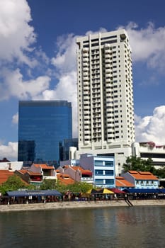 Old shop houses contrast with modern skyscrapers at Boat Quay in Singapore.