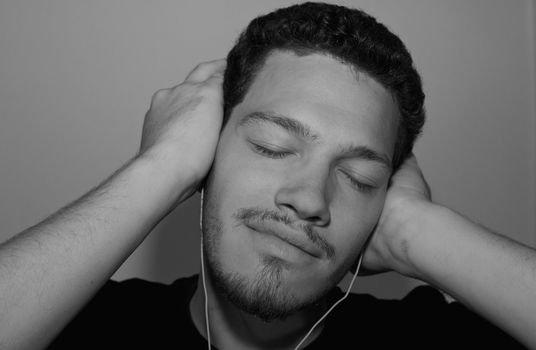 Young man listening to music through headphones