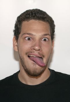 Portrait of casual young man puling a funny face isolated on white background. 