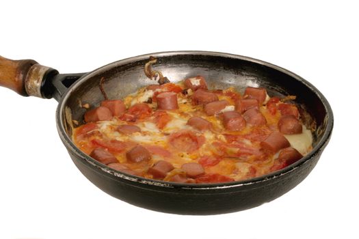 Omelette of onion,tomatoes,frankfurters and eggs in frying-pan in isolated over white