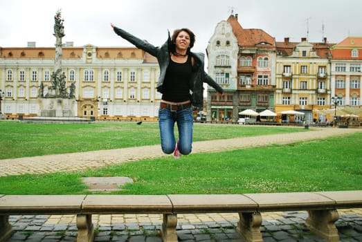 Young short hair woman jumping in a public place