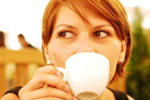 A beautiful young woman holding a cup of hot coffee