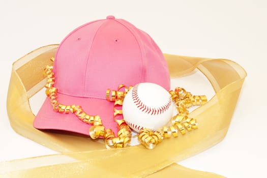 Girl's pink cap, baseball, and the glisten of gold ribbons reflect the gift of sports for girls