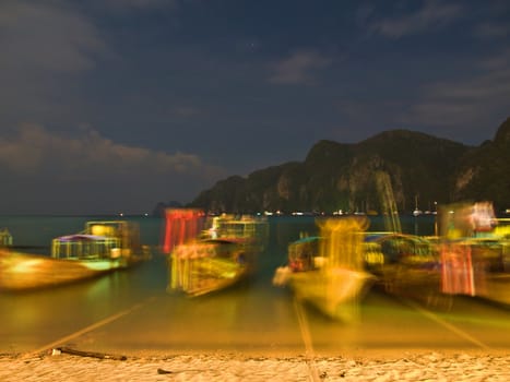 Swinging longtail boats on a beach in Thailand. Night shot.