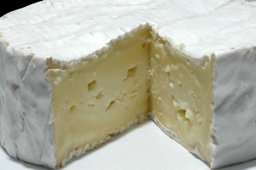 A whole camenbert cheese with a slice removed