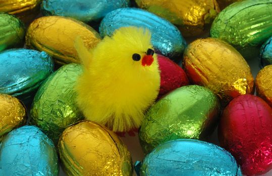 A pile of chocolate Easter eggs and a fluffy chick