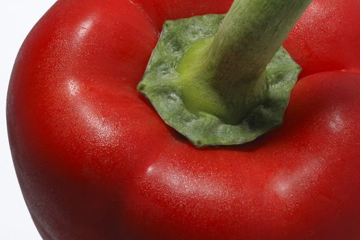 A close up of a red pepper with water mist