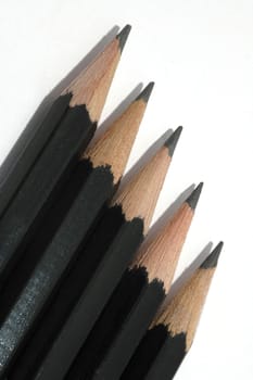 A row of 5 artist's drawing pencils