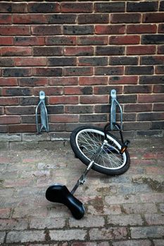 A unicycle chained to a bicycle rack