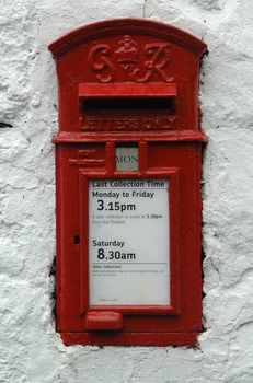 An old British Royal Mail Postbox set in a white stone wall