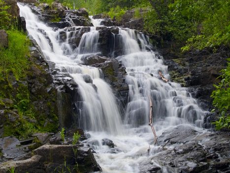 A waterfall surrounded by green spring vegetation in Northern Minnesota