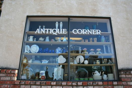Close up of an antiques sign on top of a store.

