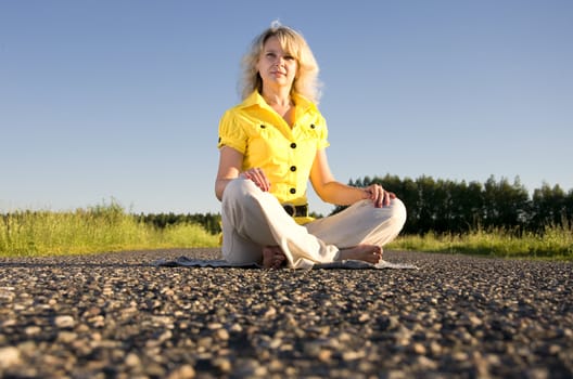 girl meditates on highway middle in rural outdors