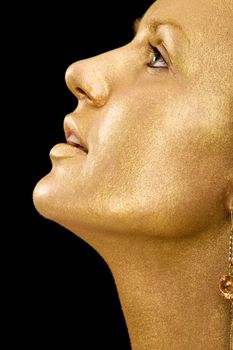 Golden profile of young woman on isolated black background