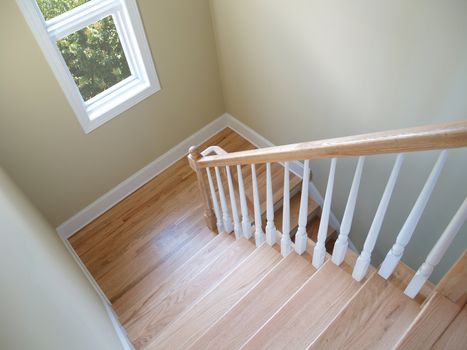 View down a wooden stairwell with a window. File includes clipping path to remove foliage outside window.