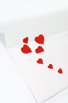 white envelope and red hearts over white