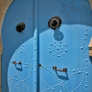 decorated blue door with grips and knockers