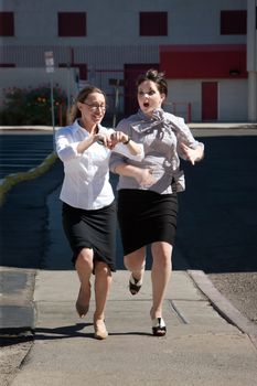 Two women are late for work and running.