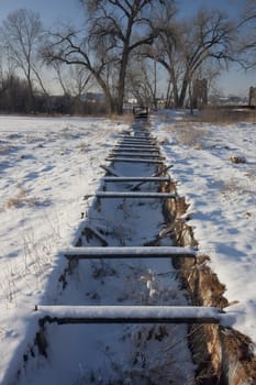 old abandoned irrigation ditch flume and aqueduct in Colorado farmland, winter scenery