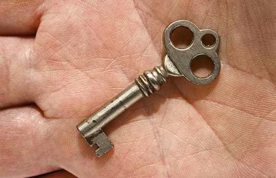 an ancient key laying on a palm