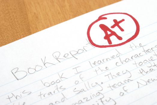 A handwritten book report is given an A plus for outstanding work.