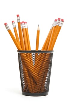 A single sharpened pencil standing upright in amoungst many other unsharpened pencils.