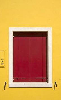 yellow wall with a red window-shutters