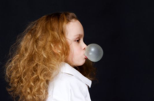 The girl inflates a bubble of a cud
