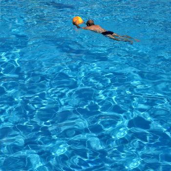 man with a ball in swiming pool 