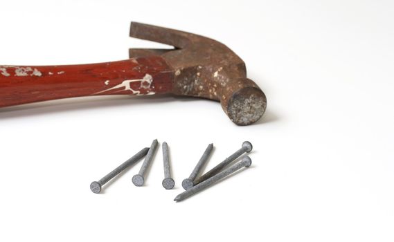 a macro picture of a hammer and nails on white