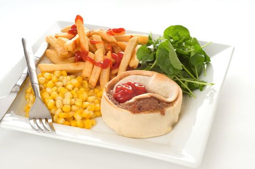 Homemade beef meat pie with fries and vegetables.